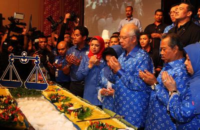 Malaysian Prime Minister Najib Abdul Razak prays with senior party members during a celebration after winning the 13th general elections 6 May 2013. (Photo: AAP).