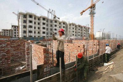 Chinese workers construct residential buildings of a government-funded housing project in Tiemenguan city, China, 2 May 2015. (Photo: AAP).