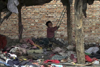 A boy, whose parents collect garbage for a living, plays on a makeshift swing at his dwelling, in Yuncheng, Shanxi province, 10 March 2015. (Photo: Reuters).