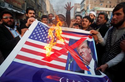 People burn a sign depicting a US flag and a picture of US President Donald Trump as they take part in an anti-US rally in Peshawar, Pakistan, 5 January 2018 (Picture: Reuters/Fayaz Aziz). 