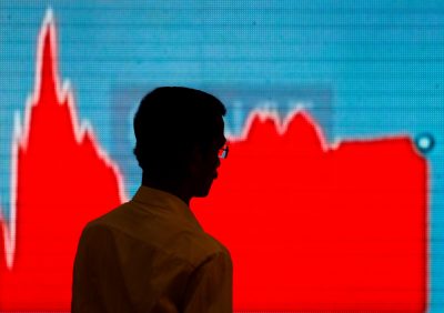A man walks past a screen displaying news of markets update inside the Bombay Stock Exchange building in Mumbai, India, 6 February 2018 (Photo: Reuters/Danish Siddiqui).