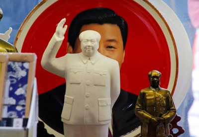 Sculptures of the late Chinese Chairman Mao Zedong are placed in front of a souvenir plate featuring a portrait of Chinese President Xi Jinping at a shop next to Tiananmen Square in Beijing, China, 1 March 2018 (Photo: Reuters/Jason Lee).