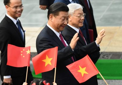 China's President Xi Jinping and Vietnam's Communist Party Secretary General Nguyen Phu Trong wave at pupils holding Vietnamese and Chinese flags, during the welcoming ceremony at the Presidential Palace in Hanoi, Vietnam, 12 November 2017 (Photo: Reuters/Hoang Dinh Nam/Pool).