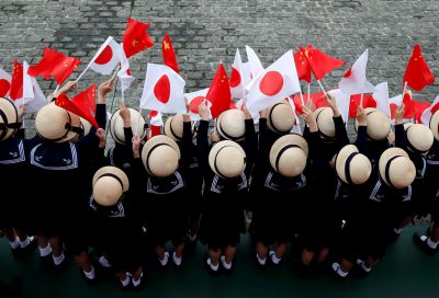 Kindergarten pupils wave national flags as Chinese Premier Li Keqiang reviews the guard of honour with Japan's Prime Minister Shinzo Abe during a welcoming ceremony before their bilateral talks at Akasaka Palace state guest house in Tokyo, Japan, 9 May 2018 (Photo: Reuters/Toru Hanai).