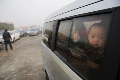 A baby looks from inside a vehicle stranded on a highway between Beijing and Hebei province, China that is closed due to smog on an extremely polluted day, 30 November 2015 (Photo: Reuters/Damir Sagolj).