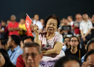 An elderly woman listens to a speech by Chee Soon Juan (not in picture), secretary-general of the opposition Singapore Democratic Party (SDP), at Chua Chu Kang stadium during a rally ahead of Singapore's September 11 election, on September 3, 2015. Campaigning for Singapore's September 11 election began September 1, with a resurgent opposition seeking a greater political role as voters chafe at immigration and high living costs. AFP PHOTO / ROSLAN RAHMAN