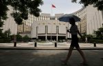A woman walks past the headquarters of the People’s Bank of China (PBoC), the central bank, in Beijing, 24 June 2016 (Photo: Reuters/Jason Lee).