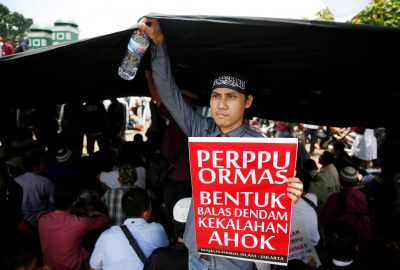 An Indonesian Islamist group member holds a placard which reads ‘regulation for mass organisations is a form of revenge for the defeated Ahok’ during a protest against President Joko Widodo's decree to disband certain groups, in front of the parliament in Jakarta, Indonesia, 24 October, 2017 (Photo: Reuters/Beawiharta).