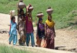 Women carry empty pitchers as they walk to collect drinking water from a well at Karondewala village in the northern Indian state of Punjab, 22 August 2009 (Photo: Reuters/Ajay Verma).