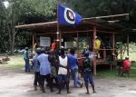 Residents hold a Bougainville flag at a polling station during a non-binding independence referendum in Arawa, on the Papua New Guinea island of Bougainville, 26 November 2019 (Photo: Reuters/Melvin Levongo).