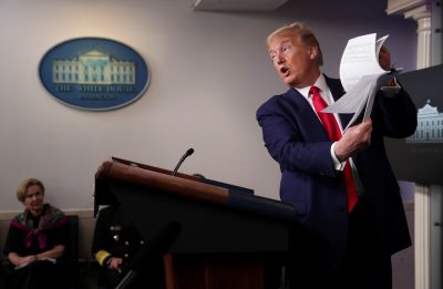 US President Donald Trump holds up a list of coronavirus testing locations that he says US states can use as he addresses the daily coronavirus task force briefing while White House coronavirus coordinator Dr Deborah Birx looks on at the White House in Washington, US, 20 April, 2020 (Photo: Reuters/Jonathan Ernst).