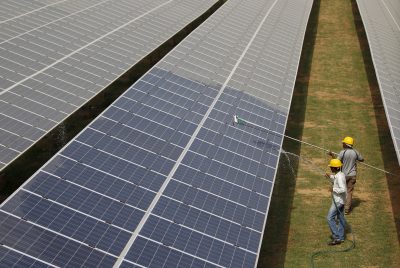Workers clean photovoltaic panels inside a solar power plant in Gujarat, India, 2 July, 2015 (Photo: Reuters/Amit Dave).