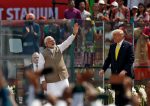 India's Prime Minister Narendra Modi waves next to U.S. President Donald Trump as they attend the 