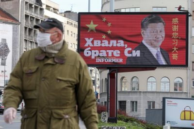 A man wearing a protective mask passes by a billboard depicting Chinese President Xi Jinping as the spread of the coronavirus disease (COVID-19) continues in Belgrade, Serbia, 1 April 2020. The text on the billboard reads 'Thanks, brother Xi' (Photo: Reuters/Djordje Kojadinovic).