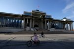People cycle past the parliament building at Genghis Square in Ulaanbaatar, Mongolia (Photo: Reuters/Jason Lee).