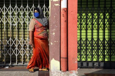 A Rohingya woman a wearing protective mask walks past closed shops amid the COVID-19 outbreak in Kuala Lumpur, Malaysia, 18 May 2020 (Photo: Reuters/Lim Huey Teng).