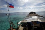 A Philippine flag flutters from BRP Sierra Madre, a dilapidated Philippine Navy ship that has been aground since 1999 and became a Philippine military detachment on the disputed Second Thomas Shoal, part of the Spratly Islands, in the South China Sea, 29 March 2014 (Reuters/ Erik De Castro/File Photo).