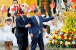 Japanese Prime Minister Yoshihide Suga and Vietnamese counterpart Nguyen Xuan Phuc (L) wave to the children during a welcome ceremony at the Presidential Palace in Hanoi, Vietnam, 19 October 2020 (Photo: Minh Hoang/Pool via Reuters).