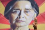 A person shows the three-fingers salute in front of a placard with the image of Aung San Suu Kyi during a protest against the military coup in Yangon, Myanmar, 15 February, 2021 (Photo: Reuters/Stringer)