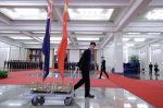 An attendant moves flags of New Zealand and China after a welcome ceremony for Prime Minister Jacinda Ardern at the Great Hall of the People in Beijing, China, 1 April 2019 (Photo: Reuters/Jason Lee).
