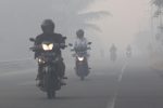 Resident drives motorcycle through haze, Suak Raya village, Indonesia, 24 July 2017 (photo: Reuters/Syifa Yulinnas)