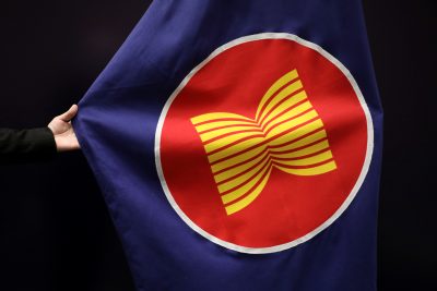 A worker adjusts an ASEAN flag at a meeting hall in Kuala Lumpur, Malaysia, 28 October 2021 (Photo: Reuters/Lim Huey Teng).