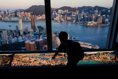 A child plays in front of skyline buildings, Hong Kong, China, 13 July 2021 (Photo: Reuters/Tyrone Siu)