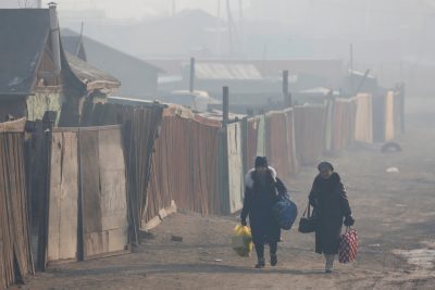 Women walk with their belongings amid smog in Sukhbaatar district of Ulaanbaatar, Mongolia, 31 January 2019. (B. Rentsendorj via Reuters Connect)