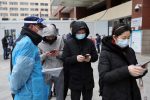 A security guard wearing a protective face shield guides people to register for a nucleic acid test at the testing site of a hospital, following the coronavirus disease (COVID-19) outbreak, in Beijing, China, 17 March 2022 (REUTERS/Tingshu Wang via Reuters Connect).