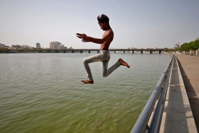 A boy jumps into the Sabarmati river to cool off during hot weather in Ahmedabad, India, 7 May 2022 (Photo: Reuters/Amit Dave).