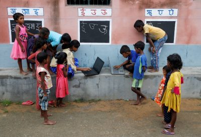 Children use laptops in an open-air class outside a house with the walls converted into black boards following the closure of their schools due to the COVID-19 outbreak, Joba Attpara village, West Bengal, India, 13 September 2021 (Photo: Reuters/Rupak De Chowdhuri).