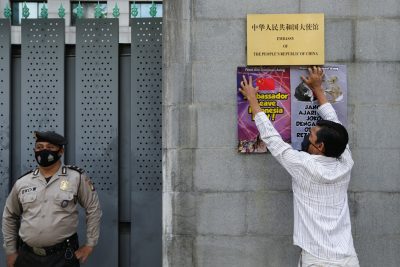 A protester sticks posters outside the Chinese embassy following reports that China has encroached on Indonesia’s maritime area in the South China Sea, in Jakarta, Indonesia, 8 December 2021 (Photo: Reuters/Ajeng Dinar Ulfiana).