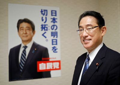 فومیو کیشیدا در کنار پوستر LDP که تصویر آبه را در توکیو، ژاپن، 2 سپتامبر 2020 نشان می دهد، ژست می گیرد (عکس: رویترز/ایسی کاتو).