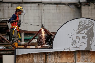 Seorang pekerja menggunakan obor saat bekerja di lokasi renovasi sebuah pusat perbelanjaan di Jakarta, Indonesia pada 30 Oktober 2020 (Foto: Reuters/Willy Kurniawan).