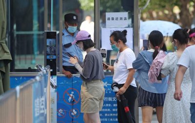 People present the 'health code' app that informs the risk of infection of COVID-19 to staff at the entrance of a commercial facility in Beijing, China, 7 July 2022 (Photo: Reuters/Koki Kataoka).