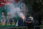 A police officer fires a tear gas shell to disperse the supporters of former Pakistani Prime Minister Imran Khan, during clashes ahead of Khan's possible arrest outside his home, in Lahore, Pakistan 14 March 2023. (Photo:Reuters/Mohsin Raza)