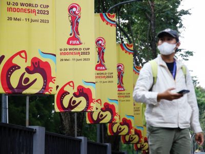 Seorang pria melewati spanduk Piala Dunia U-20 FIFA di luar kantor Konfederasi Sepak Bola Indonesia (PSSI), menyusul kemarahan di kalangan politisi atas partisipasi Israel setelah negara itu dicoret sebagai tuan rumah Piala Dunia U-20 di Jakarta, Indonesia, 30 Maret, 2023 (Foto: Reuters/ Willie Kurniawan)