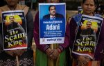Activists of the youth wing of India's main opposition Congress party hold placards featuring Gautam Adani, Chairman of Adani Group, New Delhi, India, 6 February 2023 (Photo: Reuters/Adnan Abidi).
