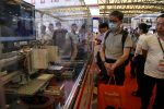 Visitors look at manufacturing equipment displayed at the THK booth during Semicon China, a trade fair for the semiconductor industry, in Shanghai, China, 29 June 2023 (Photo: REUTERS/Nicoco Chan).