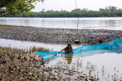 Seorang wanita sedang memancing di sungai di Chatkhira, Bangladesh.  Daerah pesisir Bangladesh terletak di 