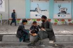 Afgan man and his children eat food in a street in Kabul, Afghanistan, 9 November 2022 (Photo: Reuters/Ali Khara).