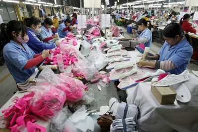 Công nhân làm việc trên dây chuyền lắp ráp tại một nhà máy giày ở làng Đan Lộp, ngoại ô Hà Nội, Việt Nam, ngày 22 tháng 2 năm 2013 (Ảnh: Reuters/Nuyen Hui Kham).