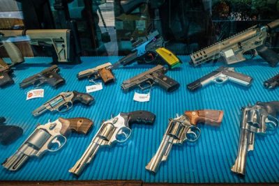 Firearms seen on display behind the front window of a gun shop in Bangkok, Thailand, 6 April 2023 (Photo: Reuters/Nathalie Jamois).
